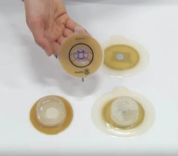 a hand holding a small container of yellow liquid