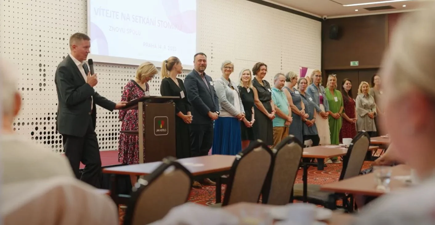 Skupina lidí stojících v místnosti