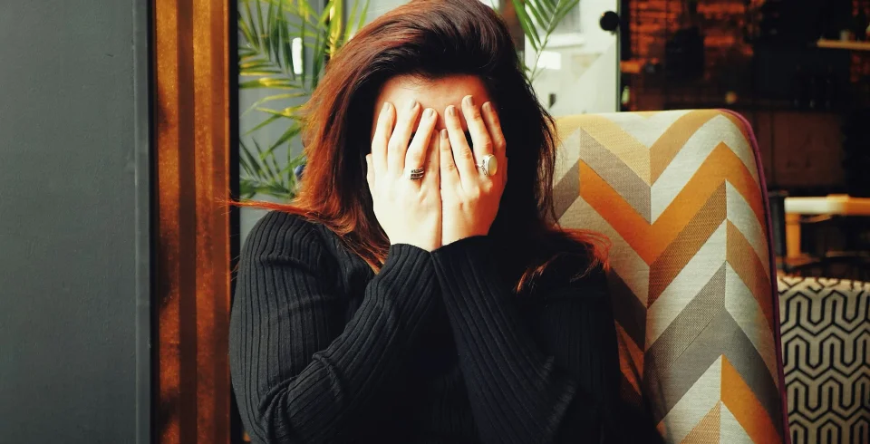 手で顔を覆う女性